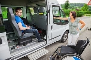 Handicapped boy is picked up by school bus Handicapped boy is picked up by school bus